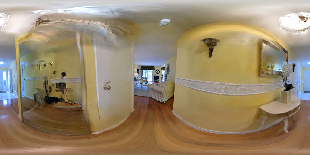 An equirectangular panorama of a house interior: hallway, mirror, doors and wooden floor, bent by the projection.